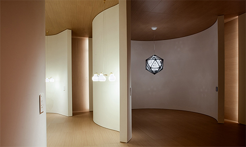 El stand de la firma danesa Louis Poulsen muestra su iluminación en una serie de alcobas curvadas