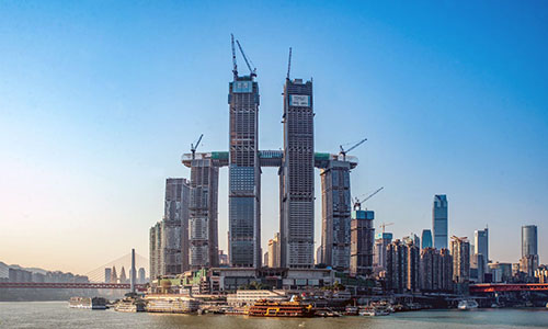 Construcción de la Raffles City Chongqing de Moshe Safdie; incluye un grupo de ocho torres y un puente aéreo.